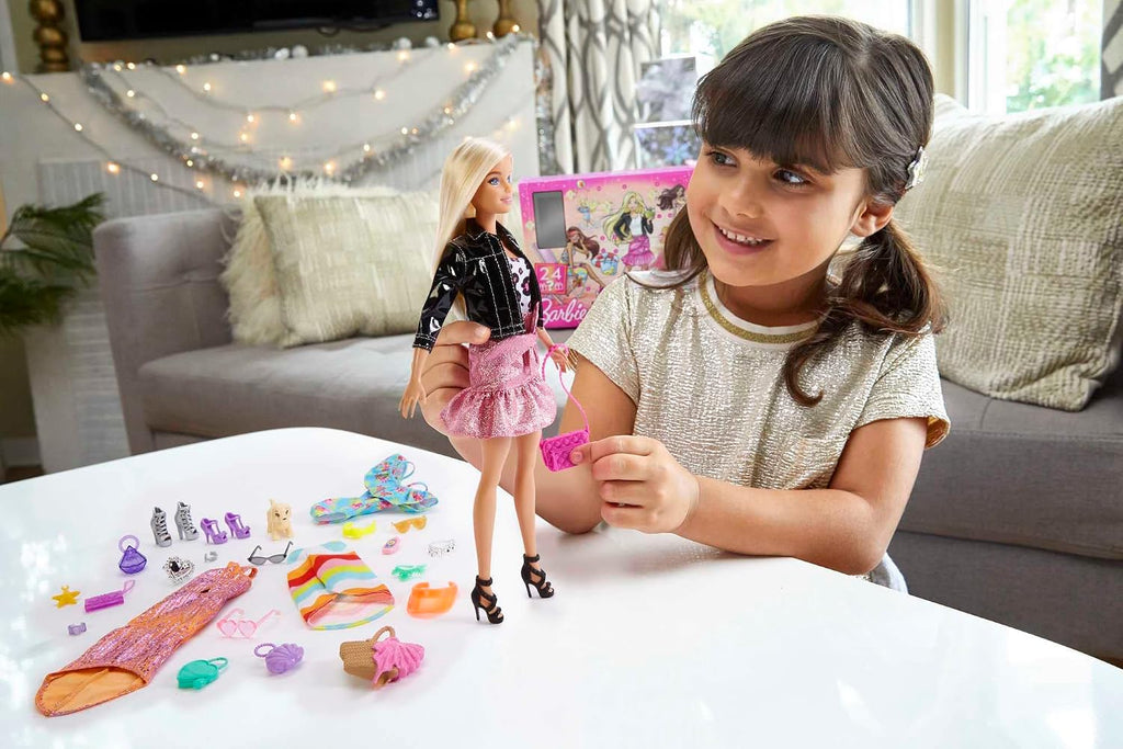 Petite fille jouant avec le calendrier de l'Avent Barbie
