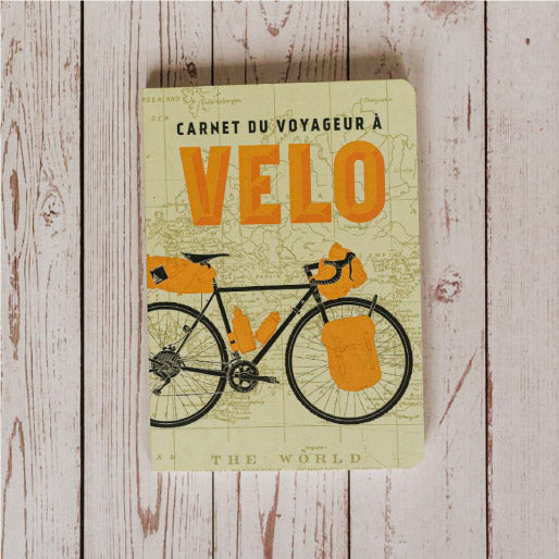 Carnet du voyageur à vélo ouvert sur une page écrite