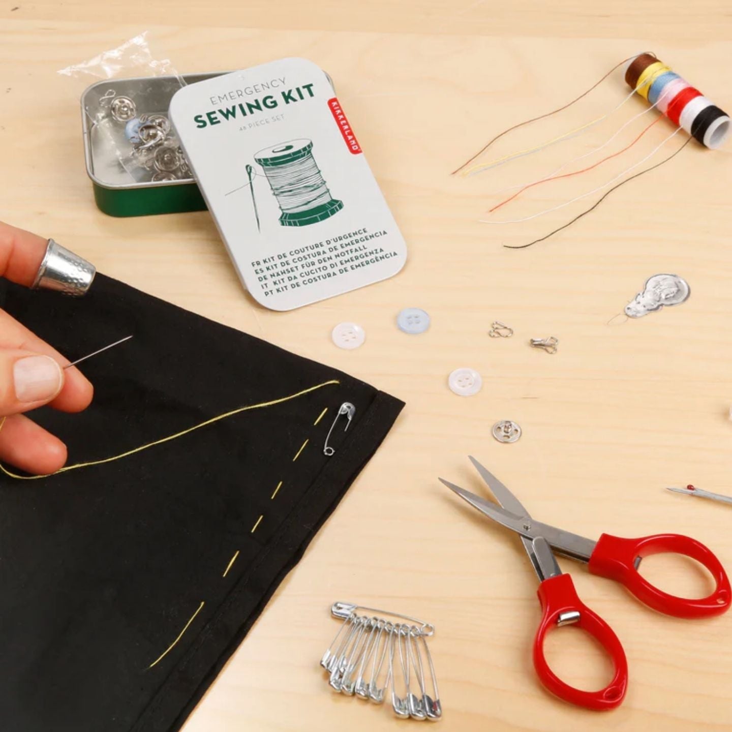 Kit de couture de secours et ses accessoires sur fond neutre