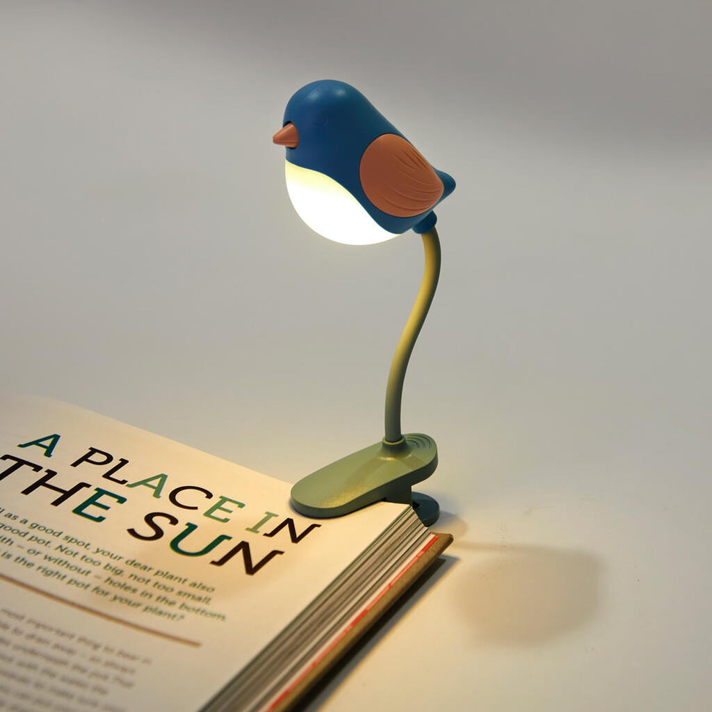 Liseuse oiseau Birdie bleue clipée sur un livre