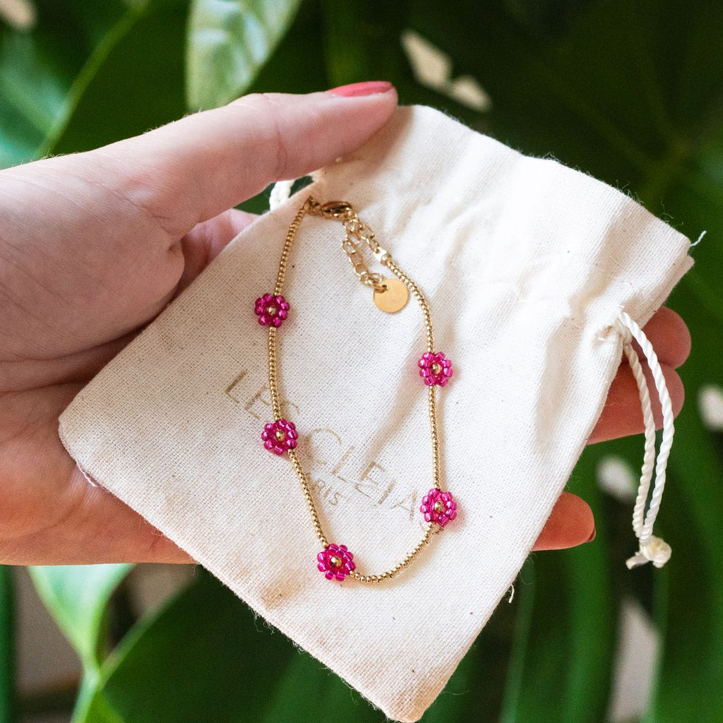 Bracelet fleuri fuchsia porté au poignet
