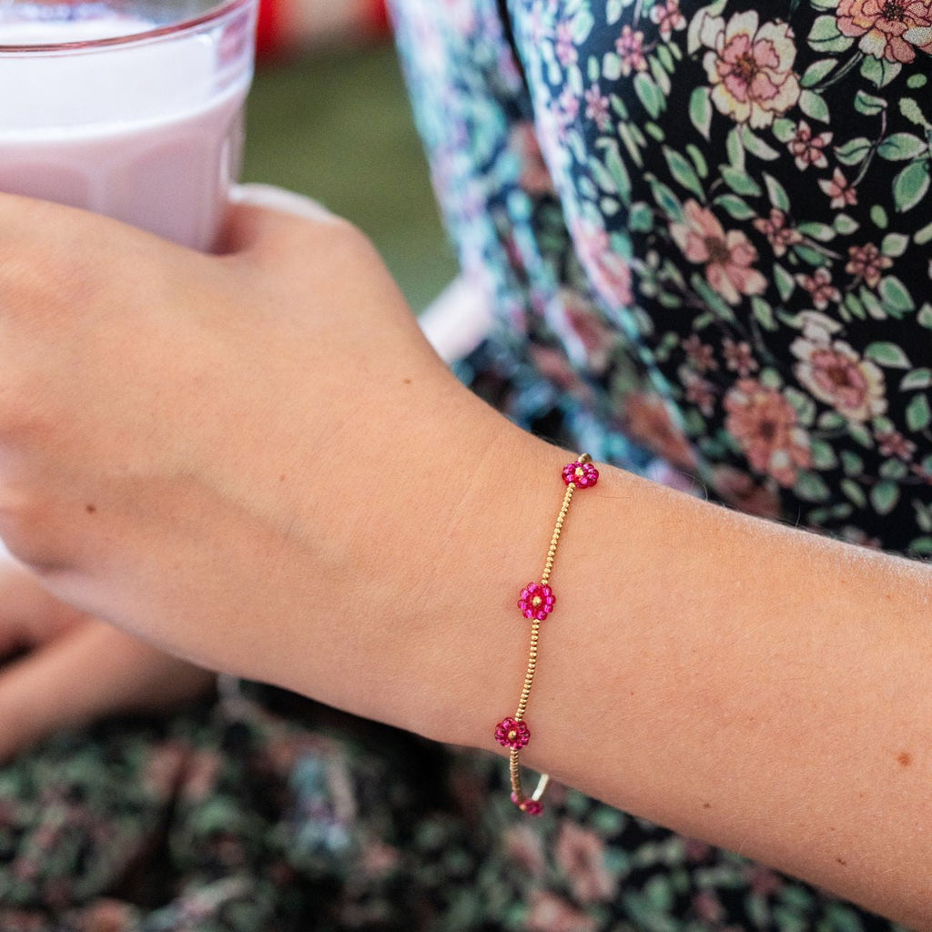 Détails dorés du bracelet marguerites fuchsia
