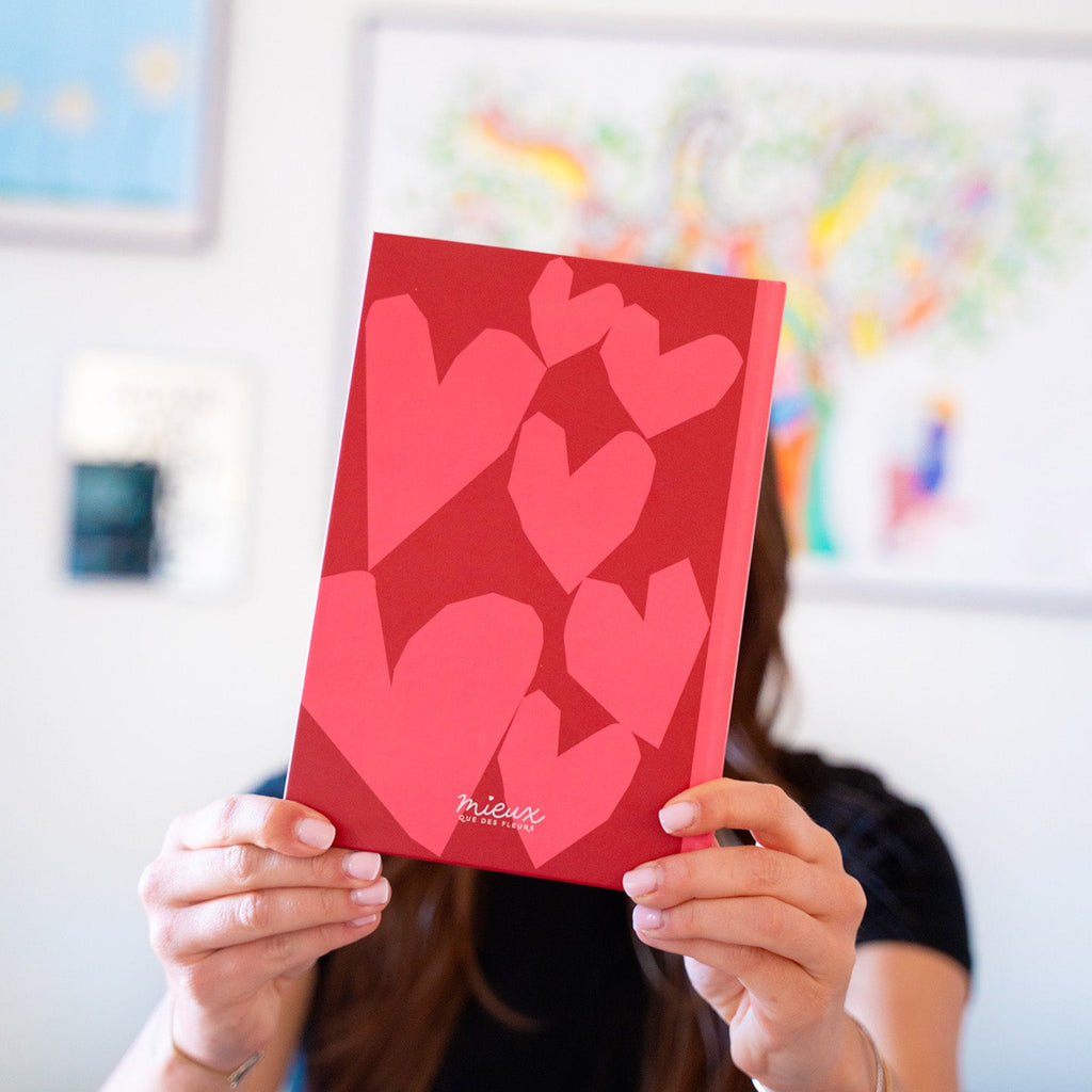 Carnet coloré à cœurs ouvert sur une page blanche