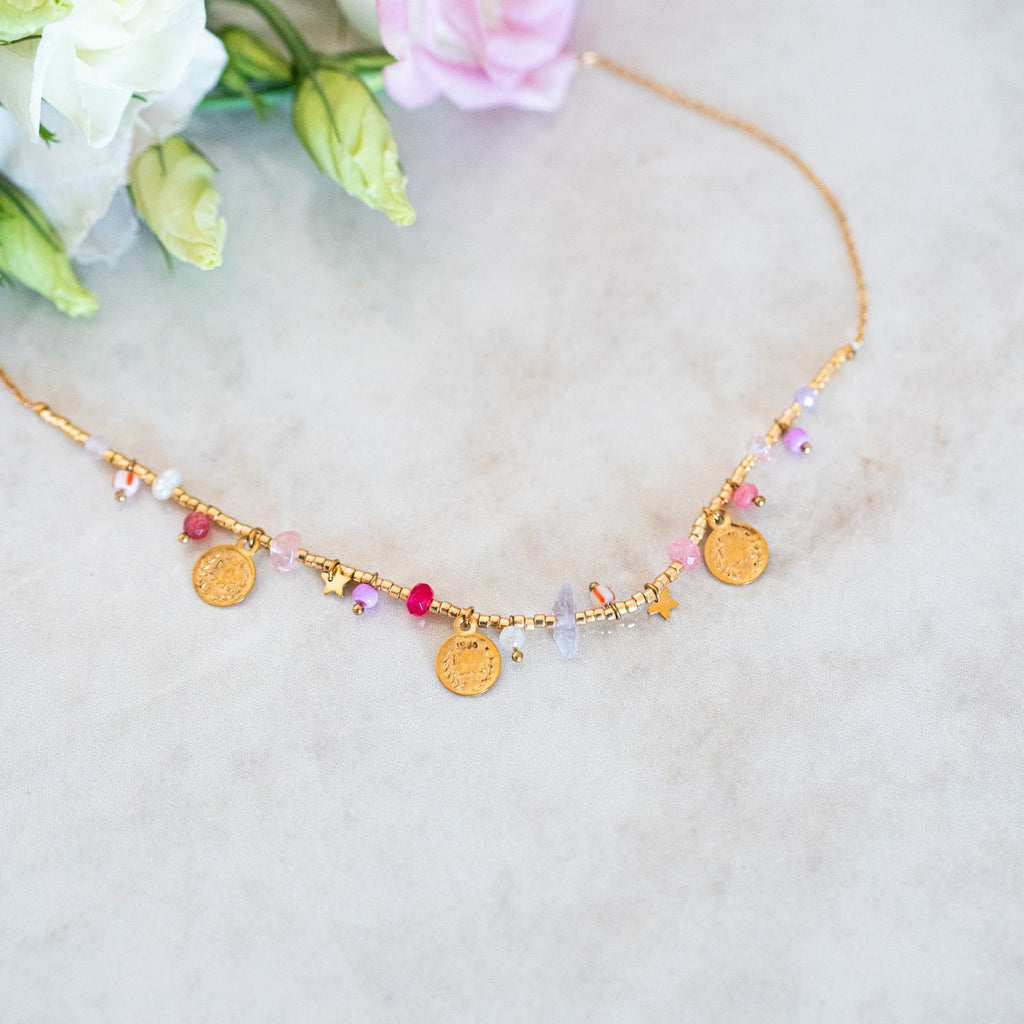 Détail des charms dorés du collier Lila en acier inoxydable