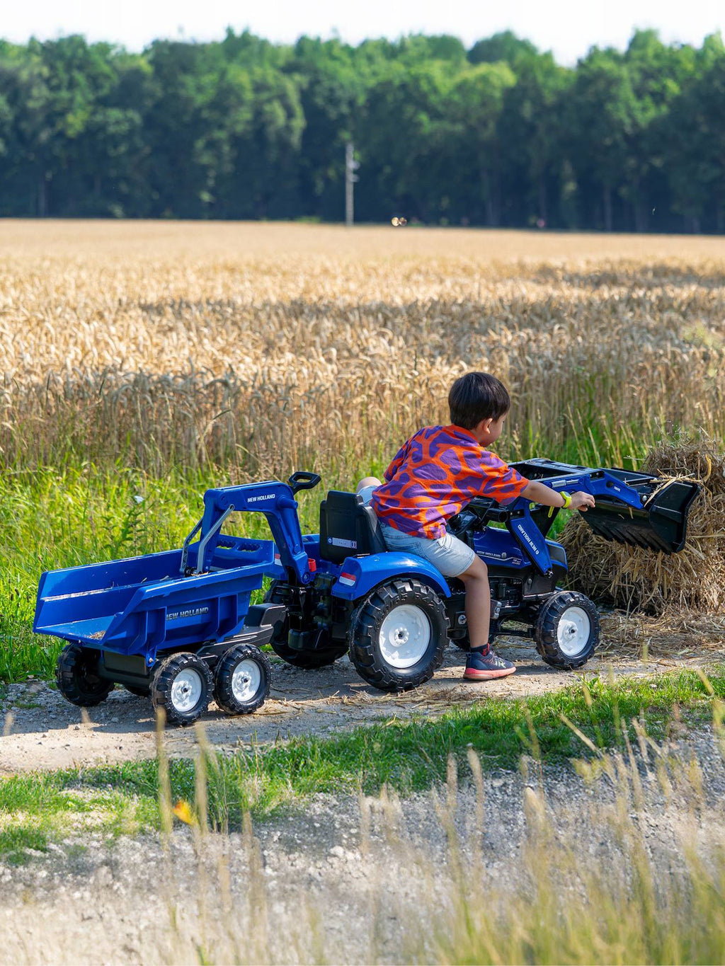 Tractopelle à pédales avec excavatrice arrière, selle pivotante et remorque double essieux basculante bleu new holland