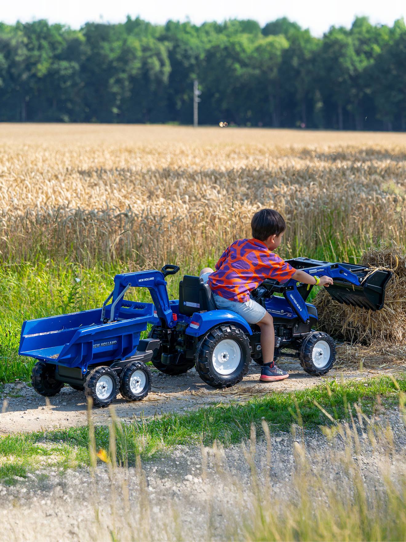 Tractopelle à pédales avec excavatrice arrière, selle pivotante et remorque double essieux basculante bleu new holland
